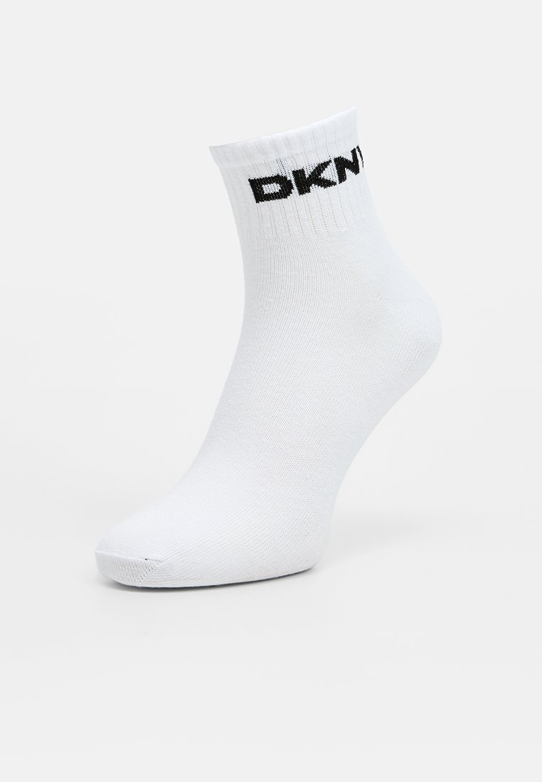 Weiße Baumwollsocken mit einem gerippten Bündchen und schwarzem "DKNY"-Logo, das nahe der Oberkante aufgedruckt ist. Glatte Textur mit einem nahtlosen Zehenbereich.