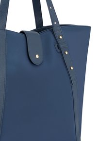 Navy blauwe draagtas met een gestructureerd ontwerp, afgewerkt met lederen randen, gouden hardware en dubbele handvatten met een bovenste sluiting.