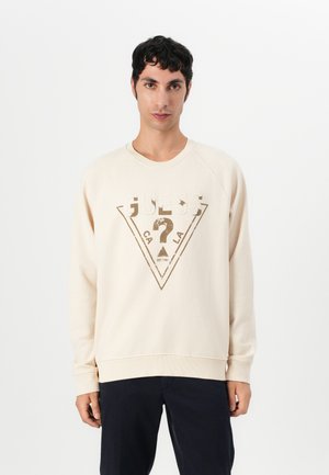 Beige sweatshirt with a crew neck, featuring a large triangle logo in metallic gold and white. Ribbed cuffs and hem, soft fabric texture.