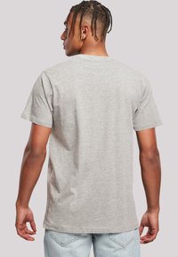 Back view of a short-sleeve, gray cotton t-shirt with a crew neckline, displaying a smooth texture and simple, classic style.