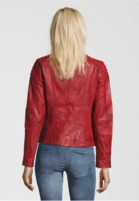 Rote Lederjacke mit tailliertem Design, strukturierte Details an Schultern und Rücken, von hinten gezeigt. Getragen über blauen Jeans.
