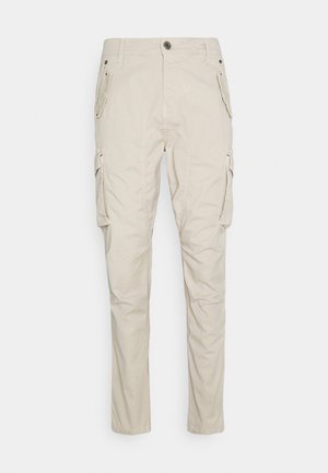 Beige cargobroek met een ontspannen pasvorm, voorzien van meerdere zijzakken, een knoopsluiting en een zachte, gestructureerde katoenstof.