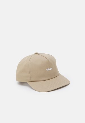 Beige baseballkasket med buet skygge og hvid "obey" tekst broderet midt for på forsiden, vist på en hvid baggrund.