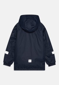 Giacca impermeabile blu navy con cappuccio, polsini elasticizzati e dettagli riflettenti. Presenta un logo quadrato vicino all'orlo. Tessuto liscio, vestibilità regolare.