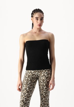 Svart strapless topp med ribbad textur och figurnära design, kombinerad med beige leopardmönstrade leggings med mörka fläckar.