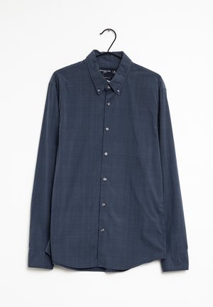 Chemise bleu marine à manches longues avec boutons et col à boutons sur un cintre noir, sur fond blanc.