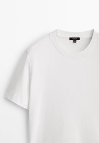 T-shirt blanc uni à manches courtes avec col rond et étiquette de taille noire visible à l'intérieur du col.