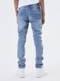 Jeans in denim blu chiaro con una vestibilità slim, caratterizzati da cinque tasche, un'etichetta in pelle sulla vita e una finitura leggermente consumata.