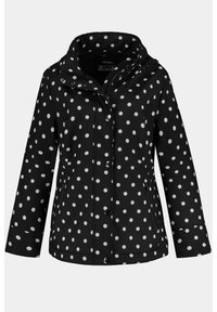 Chaqueta de lluvia negra con lunares blancos, cuenta con una capucha, bolsillos con cremallera, cierres a presión y un acabado impermeable.