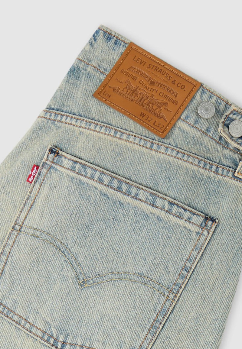 Jeans in denim azzurro chiaro con una toppa del marchio in pelle, ferramenti argento e design classico di tasca posteriore con dettagli cuciti.