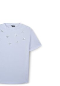 T-shirt in cotone azzurro chiaro con colletto rotondo e maniche corte, decorato con strass trasparenti a forma di fiore sul davanti.