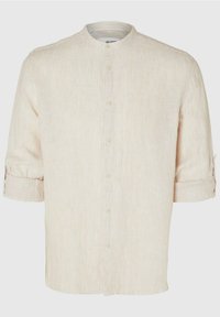 Camisa de lino abotonada con cuello mao y mangas enrolladas. Color beige claro con rayas pálidas, que cuenta con cinco botones en la parte delantera.