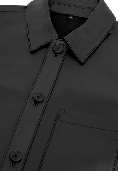 Camicia in pelle nera con colletto a punta, quattro bottoni e taschino sul petto. Texture liscia con dettagli di cucitura a contrasto.