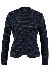 Blazer blu navy in tessuto strutturato, con pois e fodera interna testurizzata. Ha maniche lunghe e un design aperto davanti.