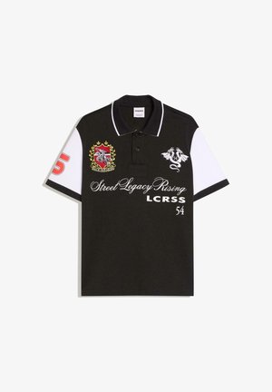 Musta-valkoinen poolopaita, jossa kaulus, vasemmassa hihaisessa punainen numero "5", vaakuna- ja lohikäärmekuvioita sekä edessä teksti "Street Legacy Rising LCRSS 54".