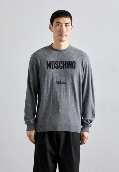 Šedý pletený svetr s dlouhými rukávy, na přední straně s černým potiskem "MOSCHINO" a "Milano". Klasický kulatý výstřih a ribbed lem.