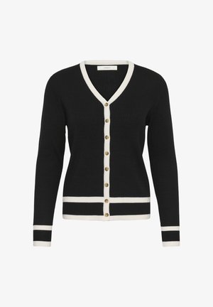 Mustast soonikangast kardigan valge äärega V-kaeluse, nööbiriba, varrukaotste ja alumise serva ümber, ees kaheksa kuldset nööpi.