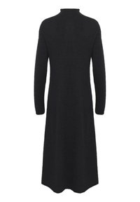 Rochie neagră cu mâneci lungi și guler înalt, fabricată dintr-un material moale. Are un corset ajustat care se lărgește până la o margine la nivelul genunchilor. Fără accesorii vizibile.
