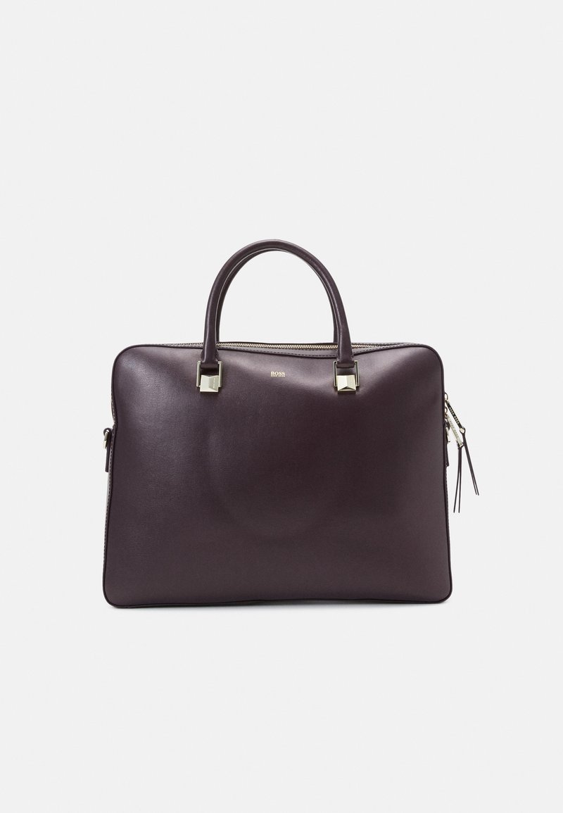 Mørkeblå læder arbejdstaske med afrundede håndtag, sølv hardware detaljer og lynlåslukning. Glat tekstur med en poleret finish.