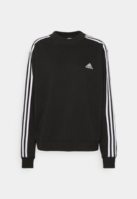 Svart sweatshirt i mjukt tyg, med hög krage, långa ärmar och tre vita ränder längs varje ärm. Litet logo på bröstet.