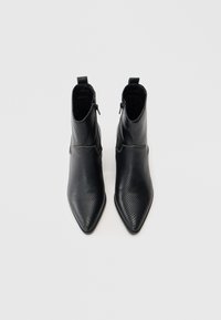 Cizme negre de gleznă din piele texturată, cu vârf ascuțit, închidere cu fermoar lateral și o finisare netedă.