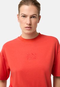 Rood katoenen T-shirt met ronde hals en korte mouwen. Voorzien van een ton-sur-ton geborduurd logo, eenvoudig ontwerp en zachte textuur.