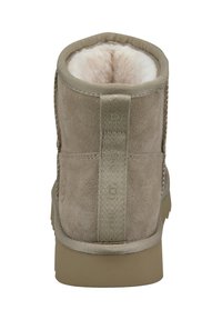 Beige Knöchelboot aus Wildleder mit einem weichen Futter aus Fell. Verfügt über eine strukturierte Fersenschlaufe und eine Gummisohle für guten Halt. Schlichtes und funktionales Design.