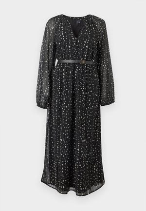 Robe midi noire à taches blanches irrégulières, manches longues en voile transparent, col en V, devant boutonné, et ceinture noire fine à la taille.