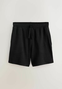 Shorts noirs mi-longue avec taille élastique et cordon de serrage, poches latérales, et tissu subtilement texturé, présentés sur un fond uni.