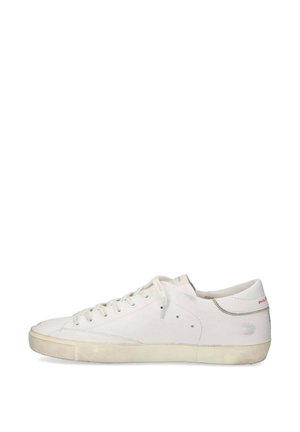 Sneaker bianca low-top con chiusura con lacci, cuciture discrete e suola in gomma leggermente usurata, vista dal lato esterno.