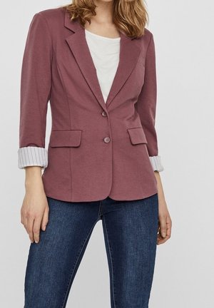 Bordeauxblazer med skräddarsydd passform, två framfickor och knappstängning. Ärmar med manschett och en kontrasterande randig design. Bärs över en vit topp.