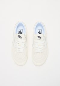 Vita sneakers med en slät läderöverdel, rund tå, minimala perforeringar och blå accenter; har platta snören och logotags på tungan.