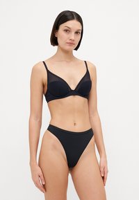 Black lingerie set featuring a structured bra with a mesh upper and lace trim, paired with high-cut matching briefs. Smooth texture.