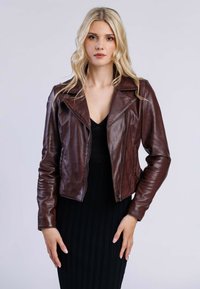 Bruine leren motorjack met een aangesloten ontwerp, brede revers en een ritsluiting. Heeft smalle mouwen en een gladde textuur.