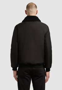 Czarna kurtka bomberka z kołnierzem z baranka, elastycznymi mankietami i gładkim, matowym wykończeniem. Charakteryzuje się czystym, minimalistycznym designem.