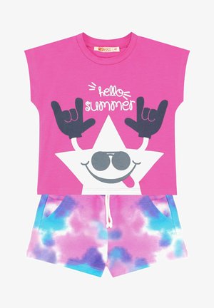 Maglietta rosa con grafica di una stella sorridente e il testo "ciao estate", abbinata a pantaloni corti tie-dye multicolori con coulisse.