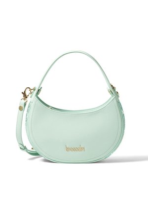 Mintgroene leren handtas met een gebogen vorm, gouden hardware en een afneembare schouderband. Opvallend merkembleem aan de voorkant.