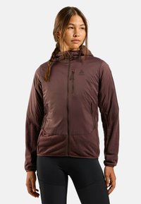 Veste à capuche bordeaux avec des manches texturées, des poches zippées et un logo sur la poitrine. Fabriquée en matériau léger et résistant aux intempéries.