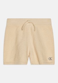 Pantaloni scurți tricotati bej cu talie ajustabilă, tiv ribbed și logo brodat. Țesătură texturată cu un design moale și casual.