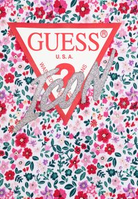 Floral-patterned fabric with red, pink, and green hues. Features a red triangular logo with "GUESS" and "ICON" in silver glitter.