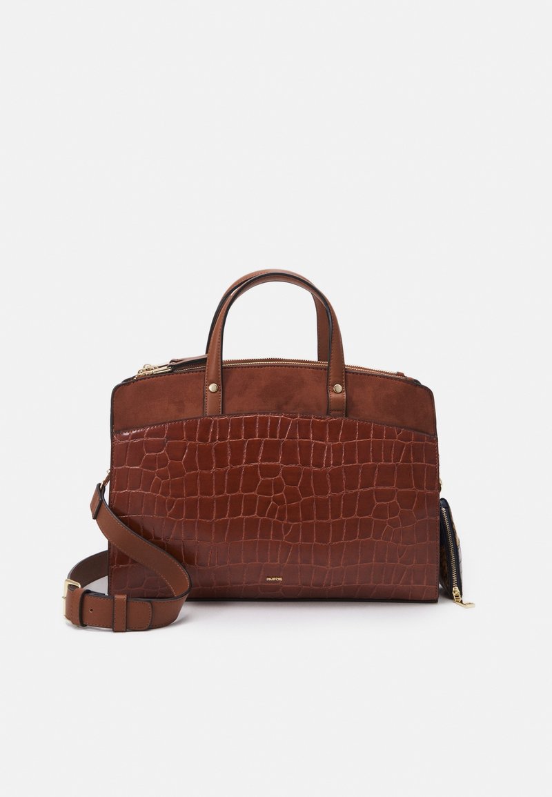 Sac à main en cuir marron avec motif crocodile, poignées supérieures, bandoulière ajustable et détails de fermeture éclair dorés sur un fond uni.