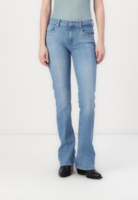Light blue denim flared jeans with front pockets, a zipper fly, and stitching accents. The fabric has a smooth texture and a casual design.