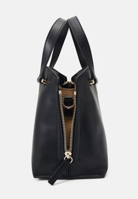 Sac à main en cuir noir avec zip doré partiellement ouvert, montrant l'intérieur beige et deux poignées noires.