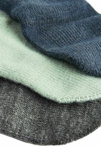 Tres muestras de tejido de punto en azul oscuro, verde menta claro y gris carbón. Cada tejido tiene una textura suave y un patrón entrelazado distintivo.