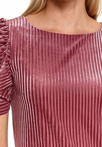 Rosa plissiertes Kleid mit glänzender Textur, kurzen Puffärmeln und weitem Ausschnitt. Vertikale Streifen erzeugen ein strukturiertes Muster auf dem Stoff.