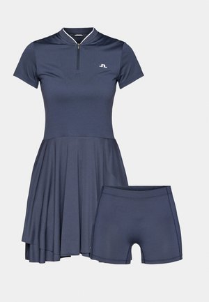 Marineblaudress mit kurzen Ärmeln und Reißverschlusskragen, featuring einem ausgestellten Rock und passenden Shorts. Glatte Textur, minimale Markenkennzeichnung.