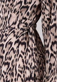 Leopard print jurk met een beige en zwarte kleurenschema, zachte stof, een wikkelontwerp en een gestrikt accent bij de taille.