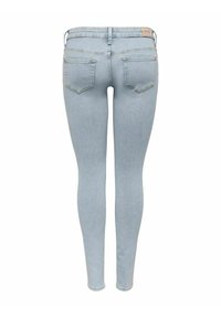 Jeans ajustados de color azul claro mostrados desde la parte posterior, con dos bolsillos traseros, trabillas para el cinturón y una pequeña etiqueta de la marca en la cinturilla.