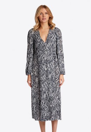 Langsleeve wikkeljurk in zwart-wit zebra print. Heeft een diepe V-hals en een textuurstof met een vloeiende silhoeet.