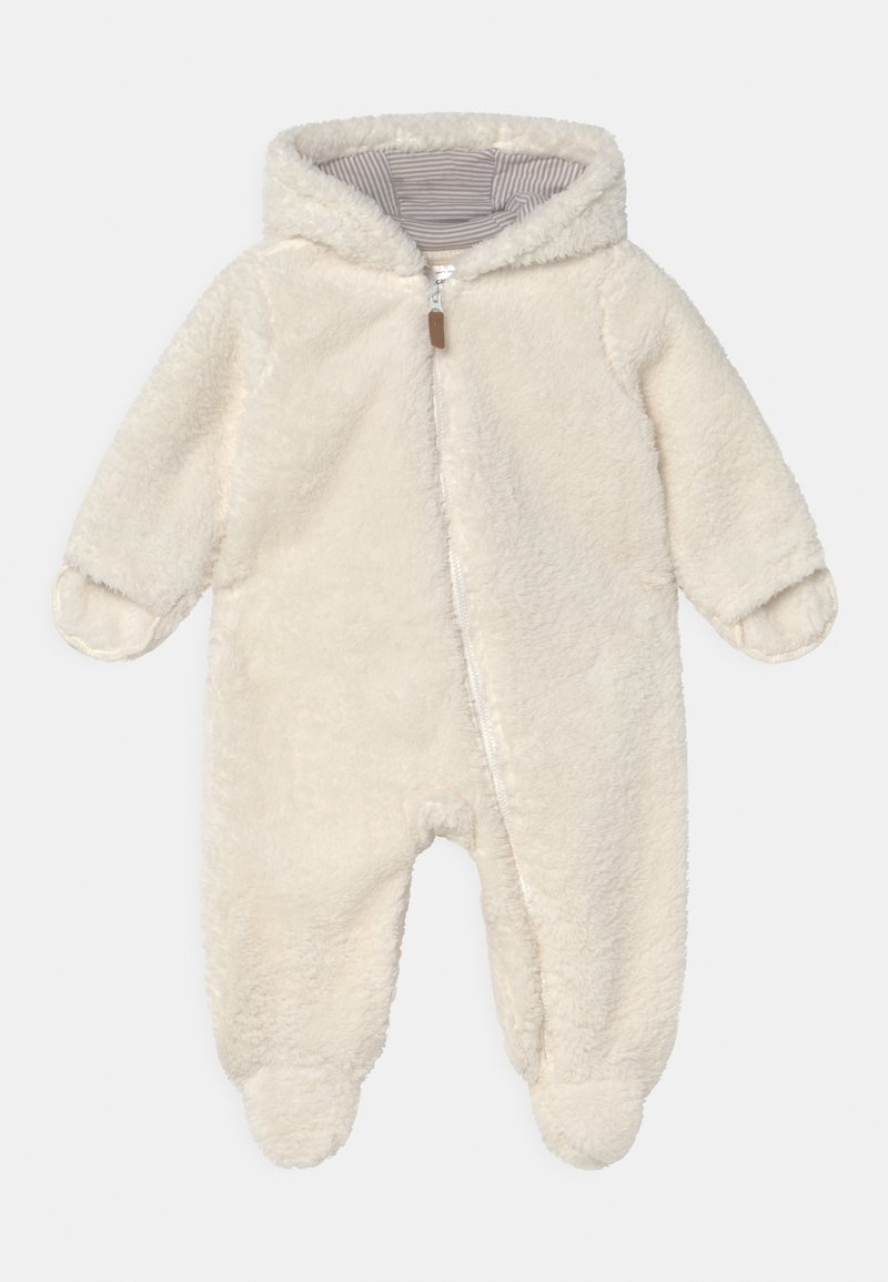 Combinaison en polaire crème avec zip intégral, capuche et doublure rayée. Comprend des pieds fermés et des poignets ronds pour plus de chaleur.